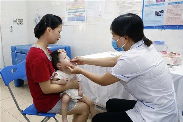 医疗站医护人员在给一名小孩吃高含量维生素 A。（图：范坚）
