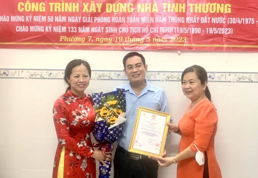 第十一郡第七坊领导向本报致谢。由编委文忠孝（中）代表接受。