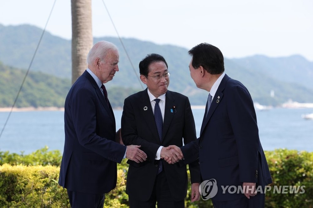 5月21日，在日本广岛，韩国总统尹锡悦（右）和美国总统拜登（左一）和日本首相岸田文雄在会谈前握手致意。 （图：韩联社）