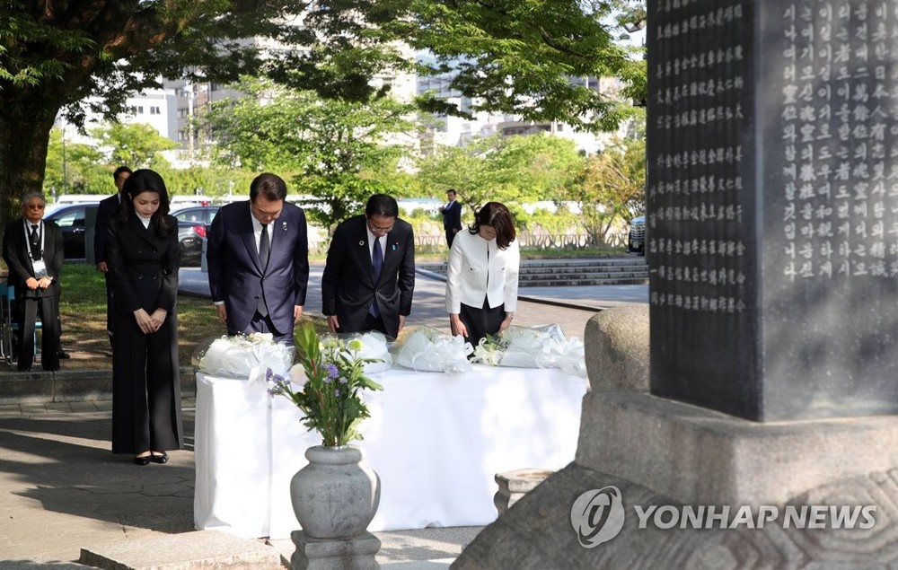 5月21日,在日本广岛和平纪念公园,韩国总统尹锡悦(左二)和夫人金建希,以及日本首相岸田文雄(右二)和夫人岸田裕子共同参拜韩国人原爆牺牲者慰灵碑。(图:韩联社)