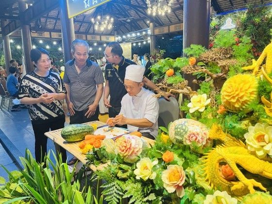 厨师在美食节上展示蔬果雕花艺术作品。