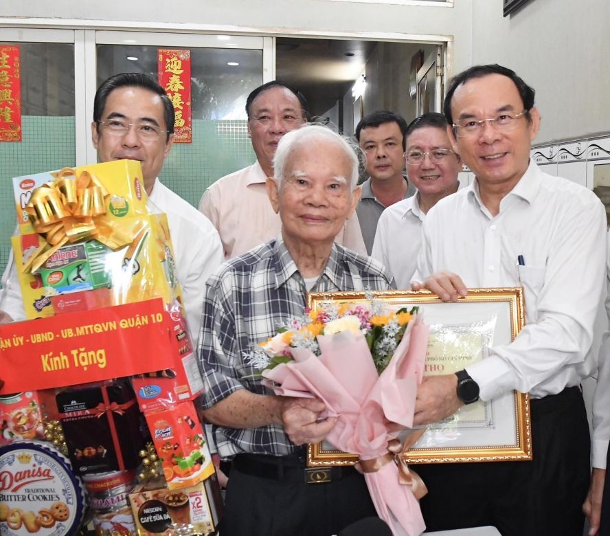 市委书记阮文年向寓居第十郡第九坊的吴光老人赠送礼物。(图:越勇)