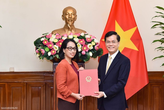 外交部新闻信息司代司长兼发言人范秋姮（左）从外交部副部长何金玉手中接过并展示人事委任《决定》。（图：国际报）