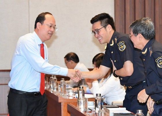 市委副书记阮胡海(左)同与会代表握手致意。(图:越勇)