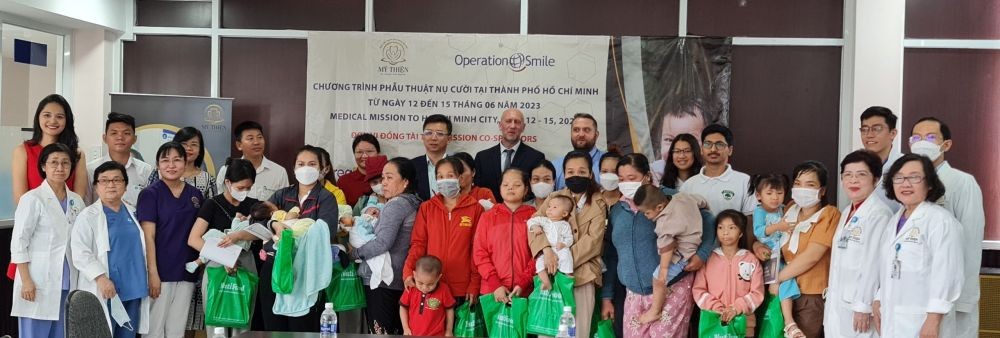 微笑手术活动的组织单位、医生、赞助商和唇腭裂儿童家庭合照。