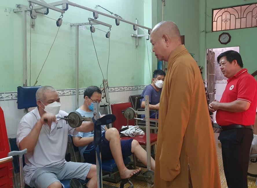 郡红十字会主席阮国明及辅助会会长释慧功法师正慰问贫困病人的身体状况。