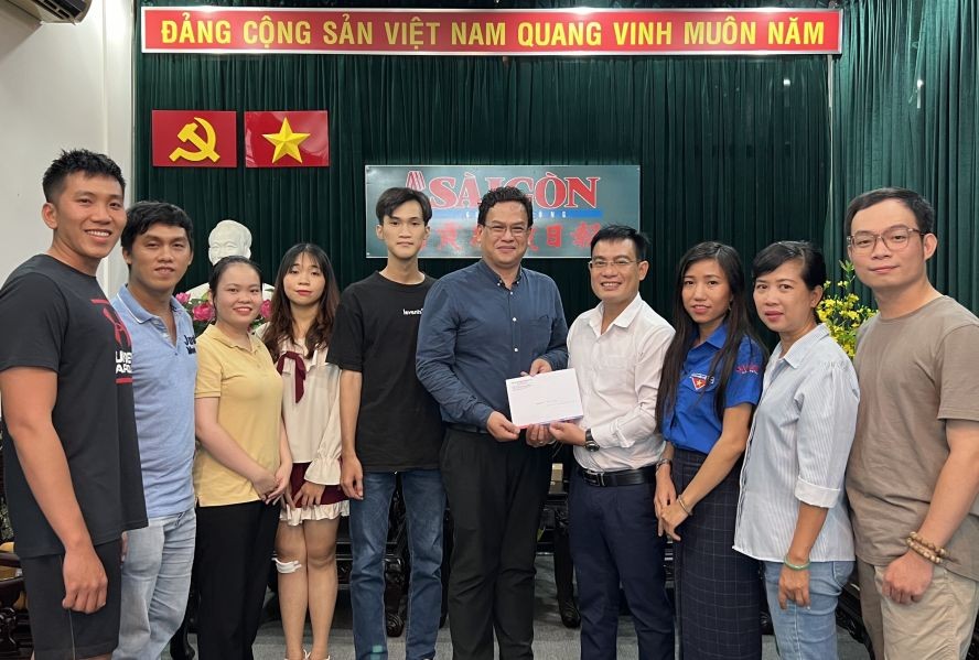 本报编委文忠孝代表接受陈志明讲师和学生们捐赠的善款。