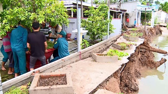职能力量协助遇河畔坍塌、导致农村道路中断的永隆省茶温县陆仕成乡居民搬迁。