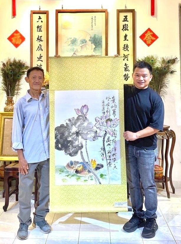 郑辉画家（左）向西堤华人文物收藏家麒麟（本文作者）捐赠作品。
