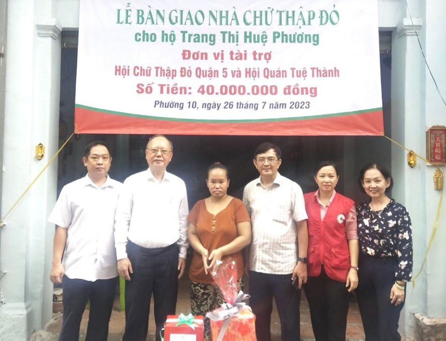 第五郡红十字会主席黎勋峰(右三）、穗城会馆理事长卢耀南（左二）与坊领导向贫困户移交“红十字会屋”工程。