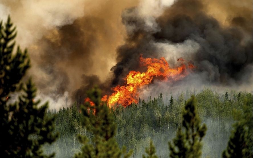 当地时间2023年7月2日，加拿大不列颠哥伦比亚省圣约翰堡北部，唐尼溪野火的火焰沿着山脊燃烧。（图：AP）