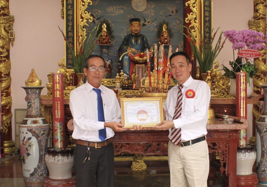 平新郡新造A坊越南祖国阵线委员会主席赖文雄（左）向郑氏宗祠理事长郑学才颁发奖状。