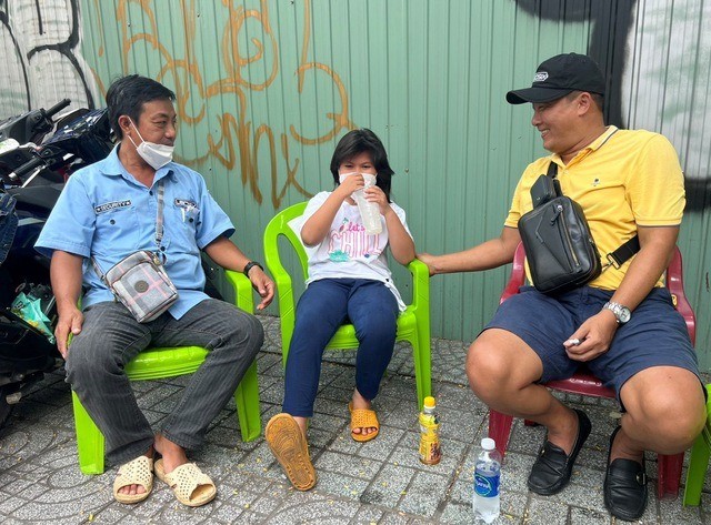 陈善方(右)与黄明忠父女交谈。原在乡下失业，现获得七哥除了安排他在某食肆店看管摩托车的工作外，还安排和给他８岁大的女儿提供住宿与上学条件。