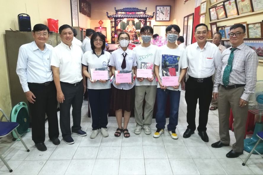 理事长关贵鸿(右一)与领奖学生合照。