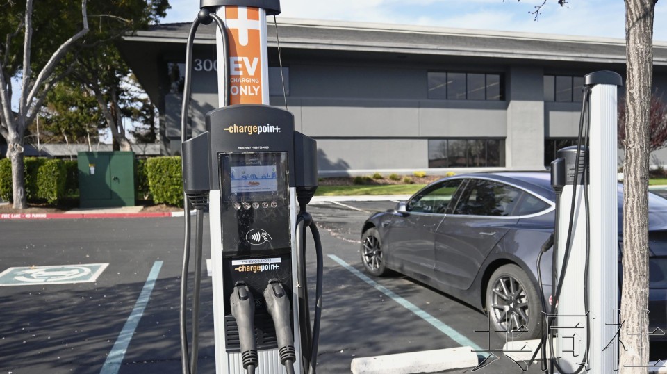 一架纯电动汽车及充电桩。（图：共同社）