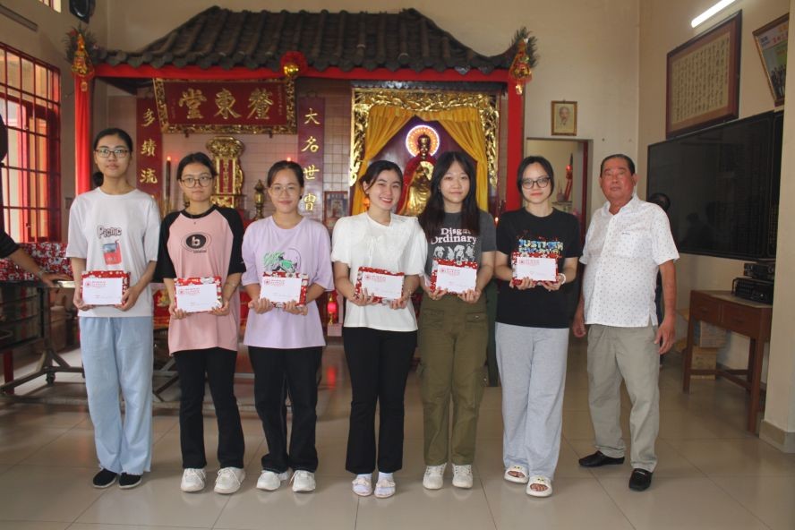 毕氏宗祠理事长毕景焯(右一)向优秀大学生派发奖学金。