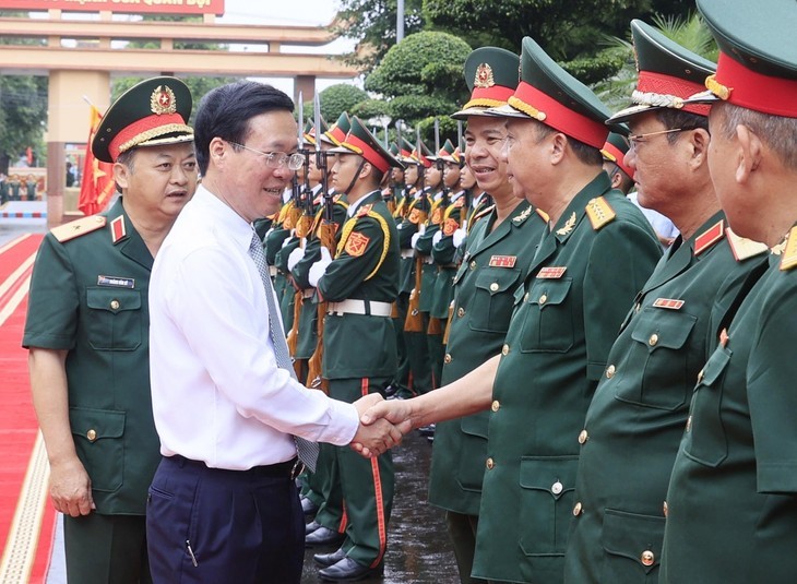 国家主席武文赏(白衣)与15号兵团干部战士握手致意。(图:越通社)