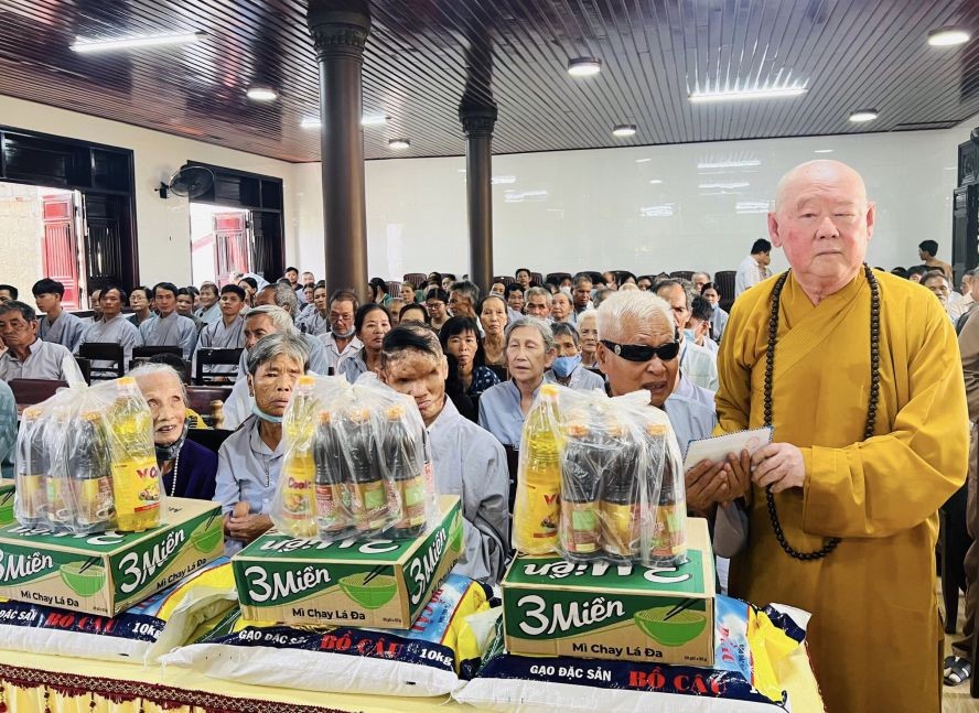 莲华寺住持释惟镇法师代表慈善团向贫困者派发礼物。