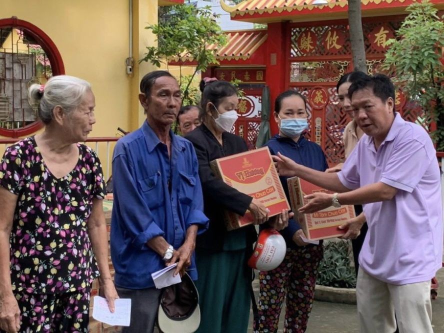 决胜村关帝庙理事长杨振明向贫困者派发盂兰节礼物。