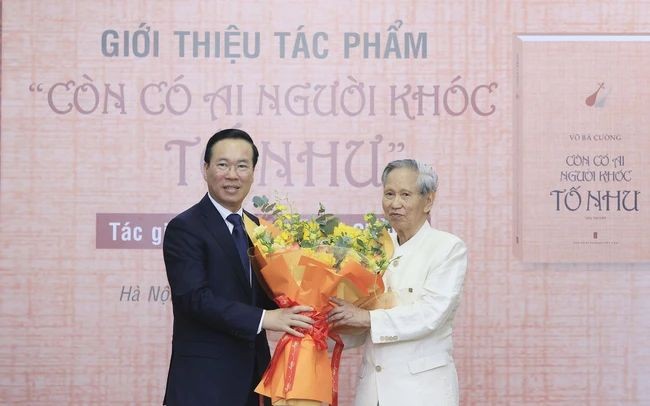 国家主席武文赏(左)向作家武伯强赠送鲜花表示祝贺。(图:越通社)