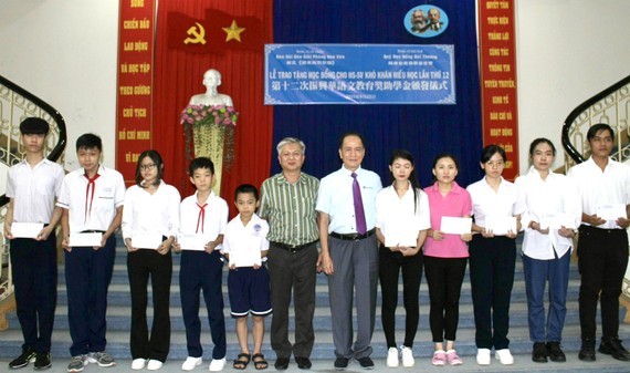 越南台商奖学金基金会董事长苏建源（右六）与华文《西贡解放日报》编委黎曰孟雄（右七）向学生颁发奖助学金。