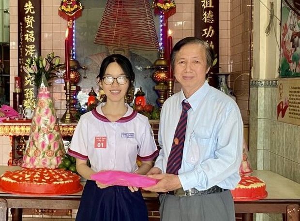 立案会长邓国鸿向获得市级数学优秀生比赛第三名邓秀娟嘉奖。