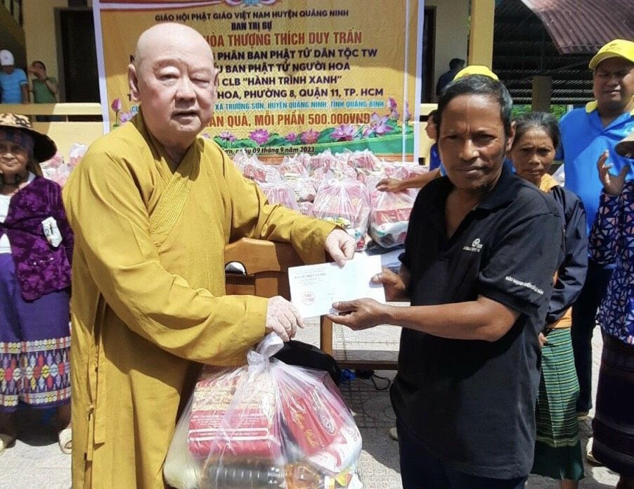 第十一郡莲华寺住持释惟镇法师向少数民族同胞赠送礼物。