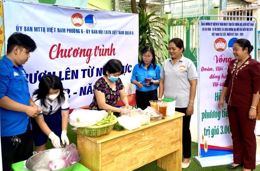 第六郡第六坊领导观看华人家庭包春卷示范。