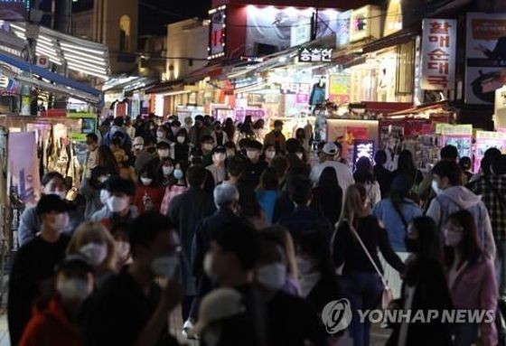 图为 2022年4月17日，弘大入口站附近商业街摩肩擦踵。（图：韩联社）