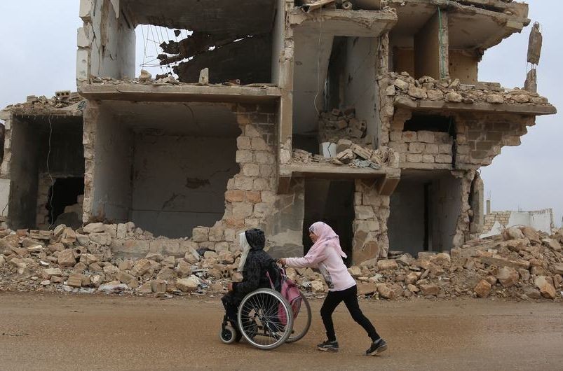 在叙利亚西北部的伊德利卜，放学后，一名女孩帮助妹妹一起回家。（图：联合国）