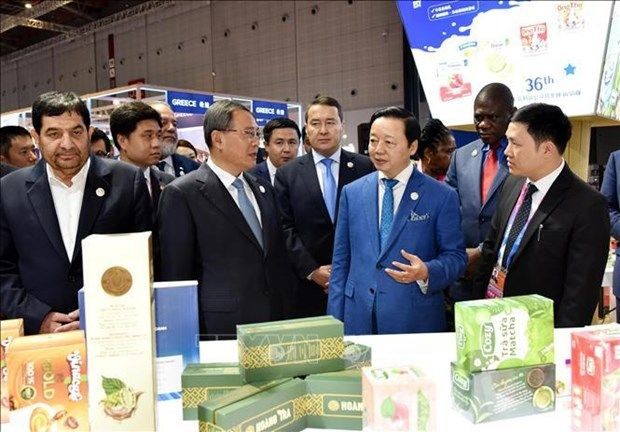 越南政府副总理陈红河在越南展位向中国总理李强及各位嘉宾介绍越南的优质商品。(图:越通社)