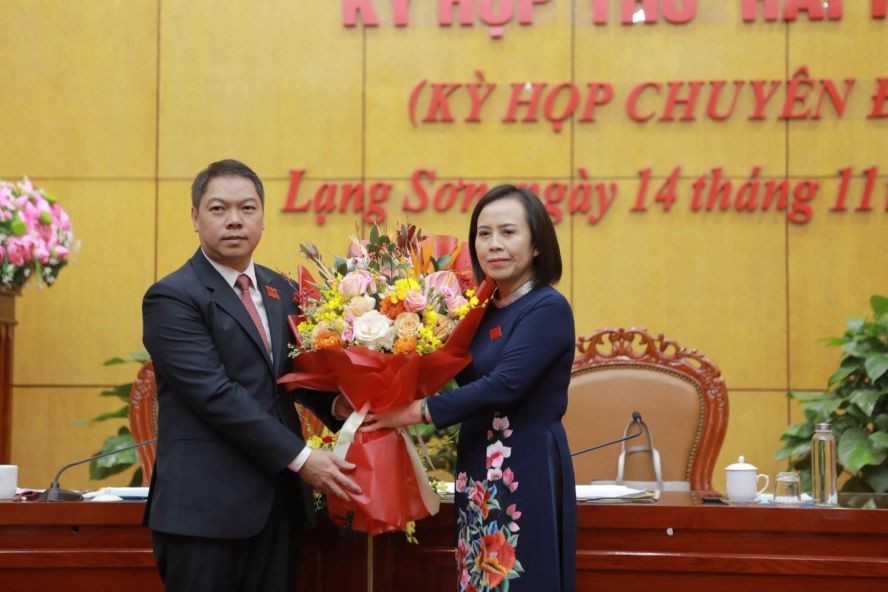 谅山省人民议会主席段氏厚(右)向段青山同志赠送鲜花表示祝贺。(图:越北)