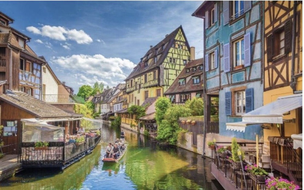 科尔马是一座被鲜花包裹着的欧洲小镇。从桥上可以看到以前船夫和洗衣店在水中的倒影，景色非常漂亮。