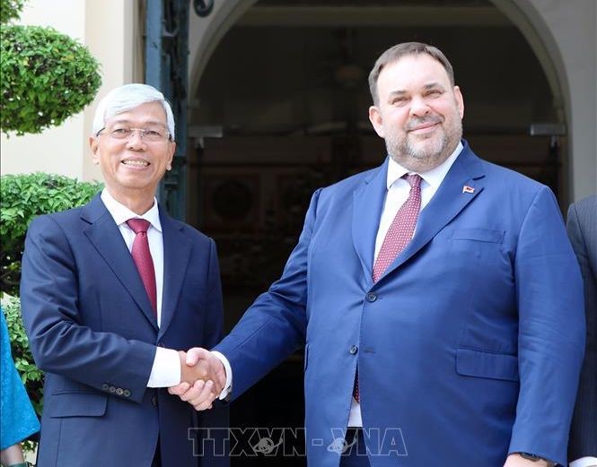 市人委会副主席武文欢（左）与白俄罗斯外交部副部长叶夫根尼‧谢斯塔科夫握手合影。（图：越通社）