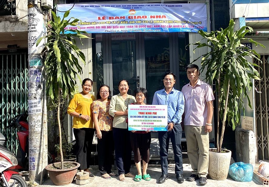 第六郡坊领导和本报领导等向罗丽娇移交温情屋。