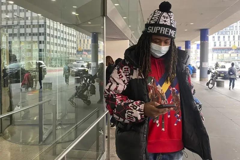 纽约一名男子戴着口罩去做检查,结束后在医院外等车。(图:AP)