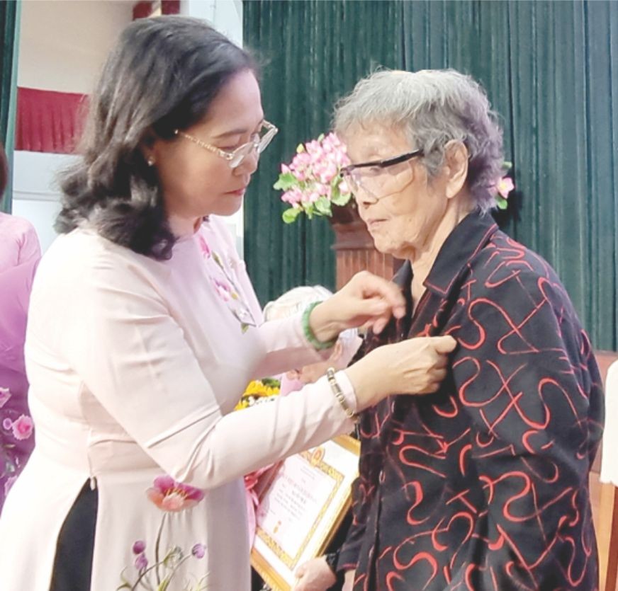 市人民议会主席阮氏丽向本报原干部何黛颁发60年党龄纪念章。 trao-huy-chuong-4582.jpg