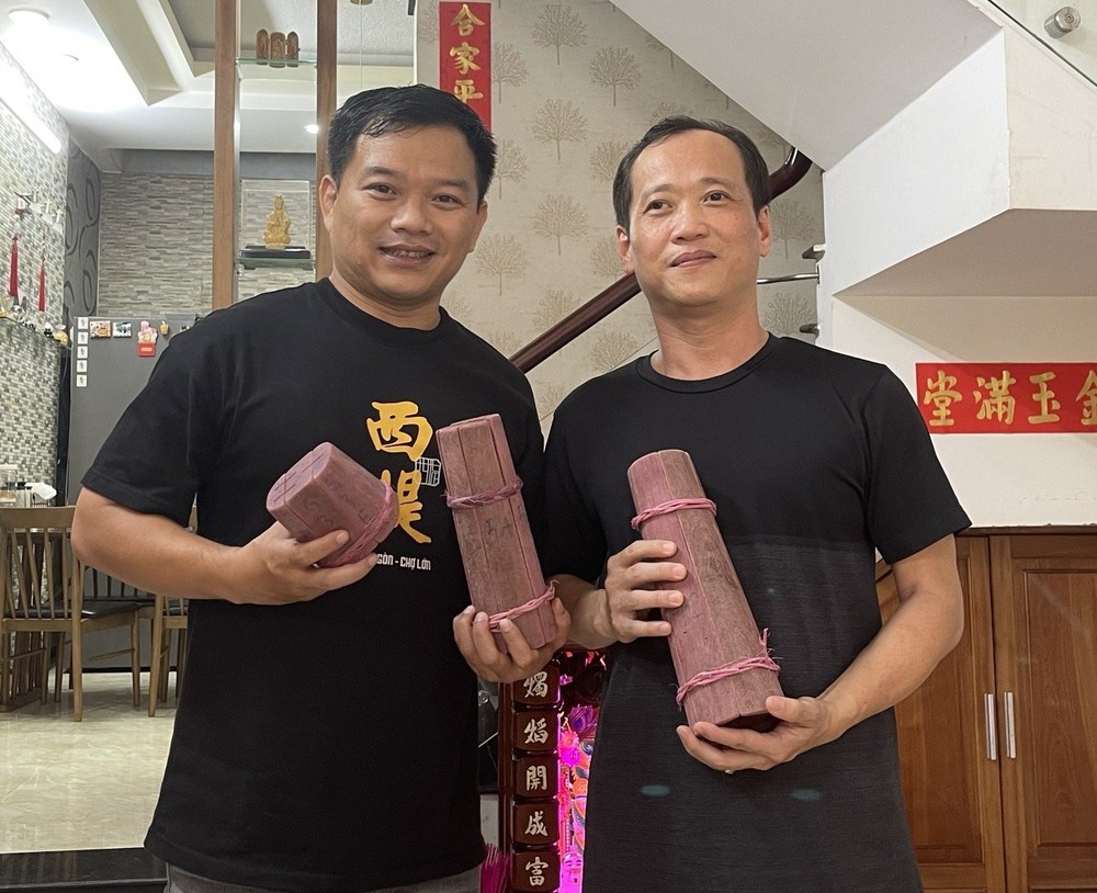 郑飞裕(右)向笔者赠送家里留着的最后一套糖塔与糖鸡木模。 t2-2-5406.jpg