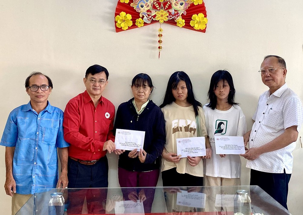 第五郡红十字会主席黎勳丰(左二);该会副主席兼穗城会馆理事长卢耀南(右一)向已故黎氏红雪家属转交款项。