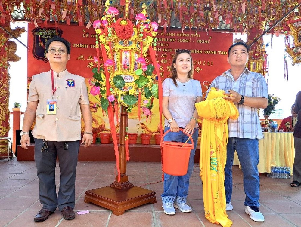 理事长邹国荣把“观音莲花宝灯”移交给邓奕波伉俪。