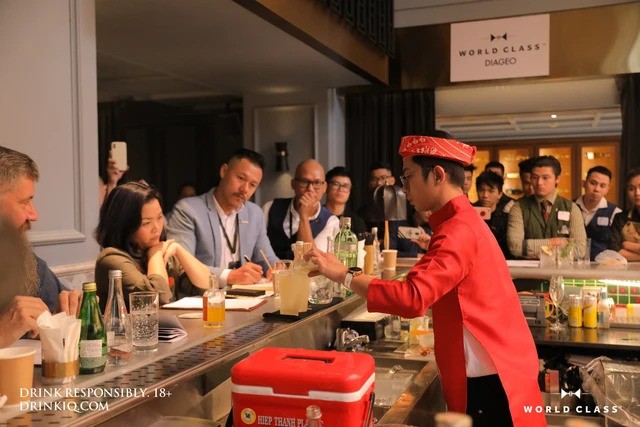 在一次世界调酒比赛上，宇玉身穿越南长衫表演调酒艺术。