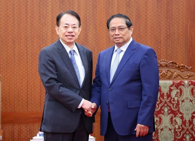 政府总理范明政(右)与亚洲开发银行行长浅川雅嗣握手合影。(图:越通社)