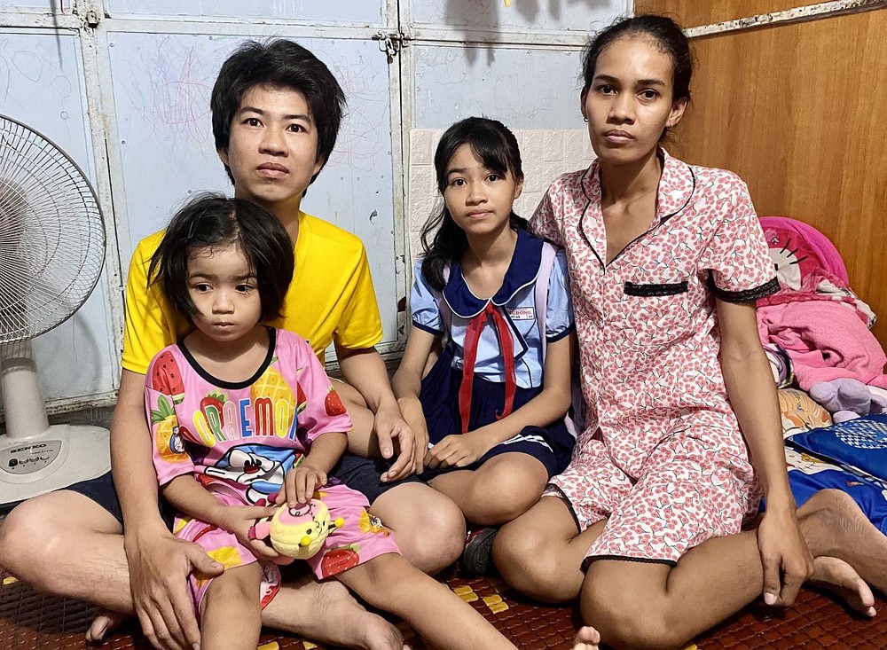 陈富创与妻女在租住的房间里。