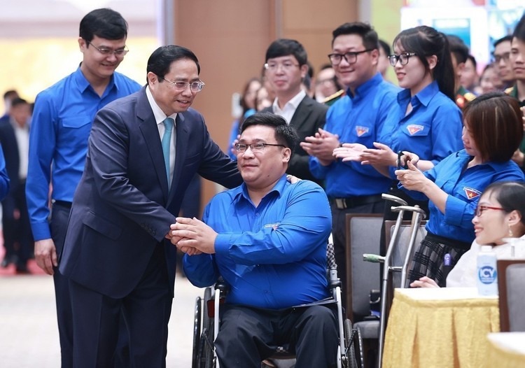 政府总理范明政向处境特殊的共青团员亲切问候。（图：越通社）