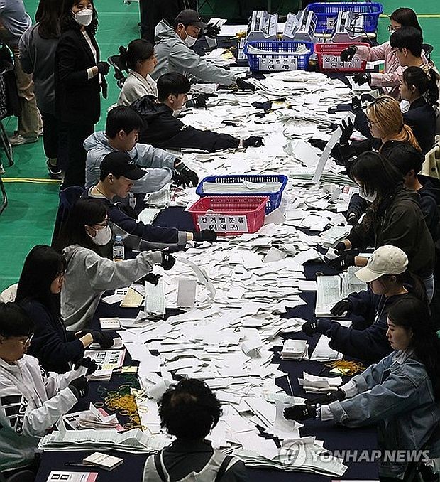 4月10日，在设于首尔大学校综合体育馆的计票站，工作人员正在进行计票工作。韩国第22届国会议员选举正式投票当天进行，计票工作从当晚6点30分起开展。 （图：韩联社）