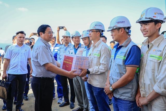 政府总理范明政向工地上的工人赠送鼓励礼物。(图:VGP)