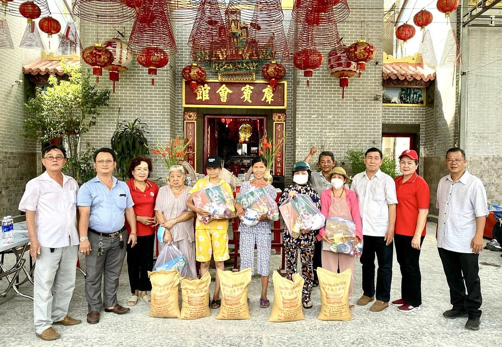 曾文良主席(右二)和各位理监事向穷苦人家派发礼物。