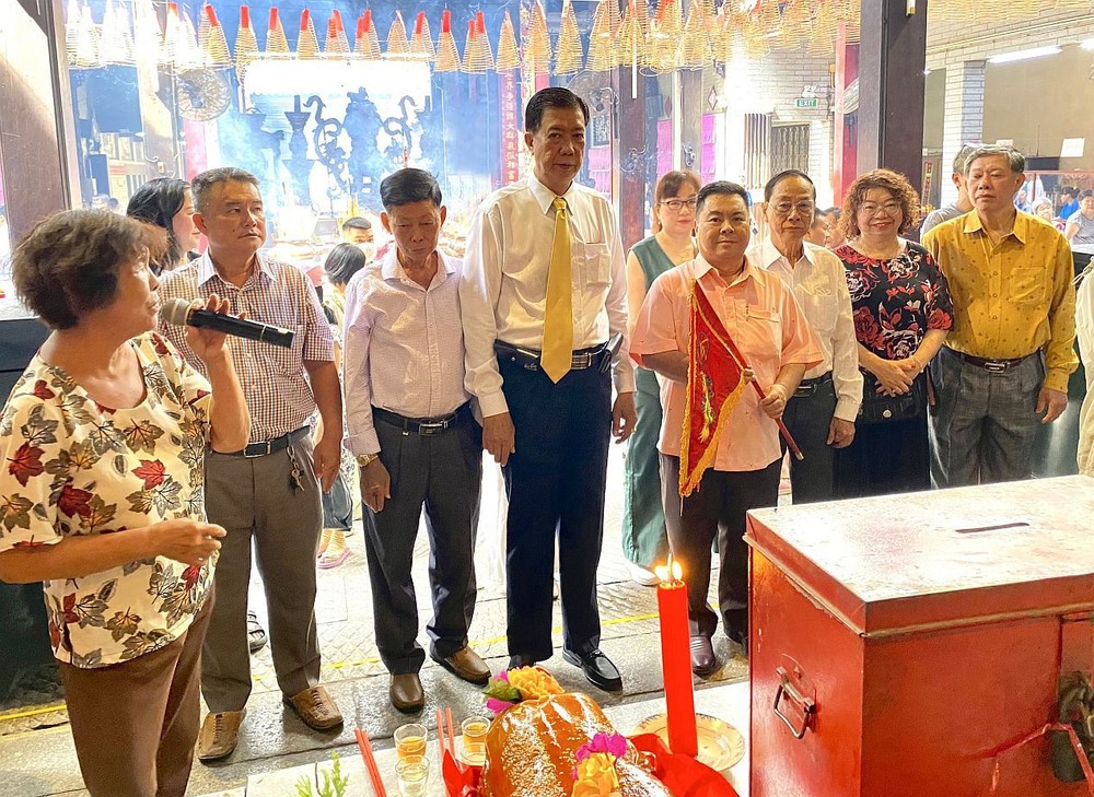 穗城会馆副理事长林海泉(左四)将天后圣母令旗移交给统一粤剧团顾问会长丁文森。
