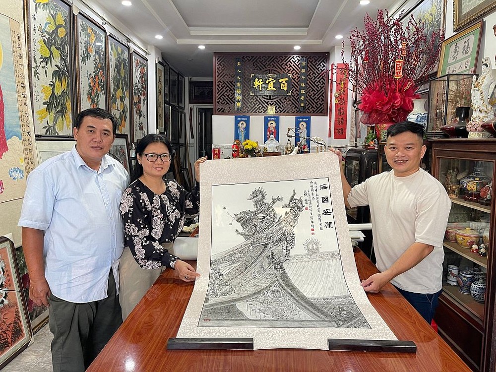 郑钊城与姚金鸾夫妇（左一、二）把《海国安澜》作品交予笔者。