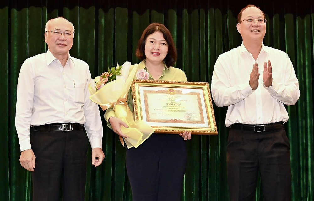 市委常务副书记、市委第35号指委会主任阮胡海(右一)和市委宣教处主任、市委第35号指委会副主任潘阮如奎(左一)向富润郡颁发奖状。(图:越勇)